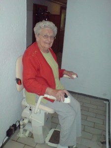 Ältere Dame auf Treppenlift
